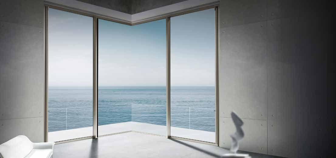 Slim-line aluminium corner window opening onto an ocean view