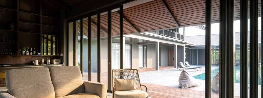 Folding doors opening a living room onto a pool deck